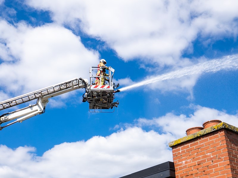 Aerial ladder platform extended and using hose