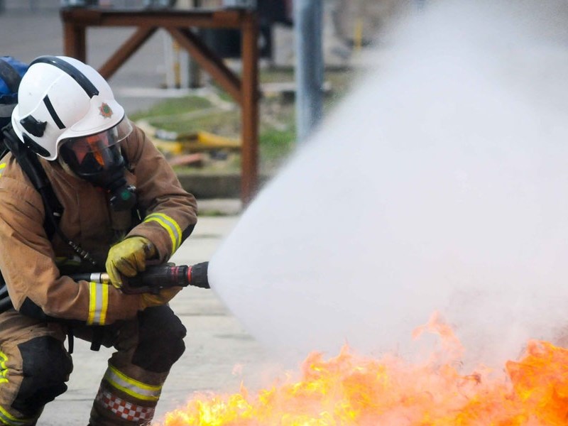 Firefighter tackling flames with hose