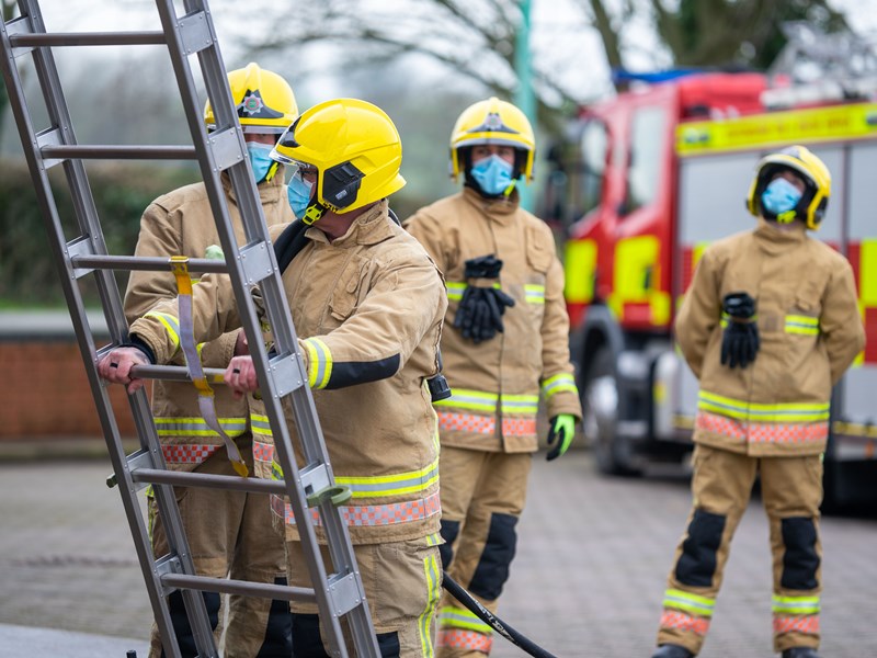 Group of firefighters at the bottom of a ladder