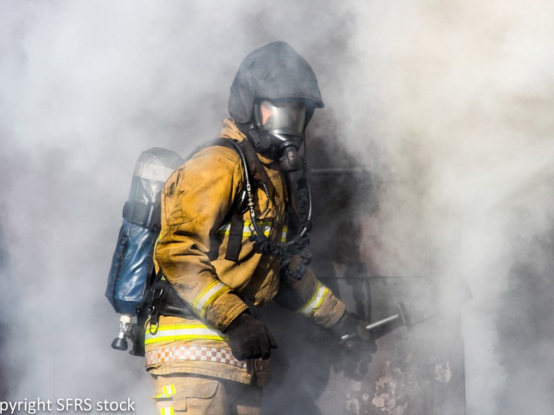 Firefighter coming out of cloud of smoke