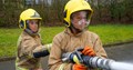 Two female firefighters using hose
