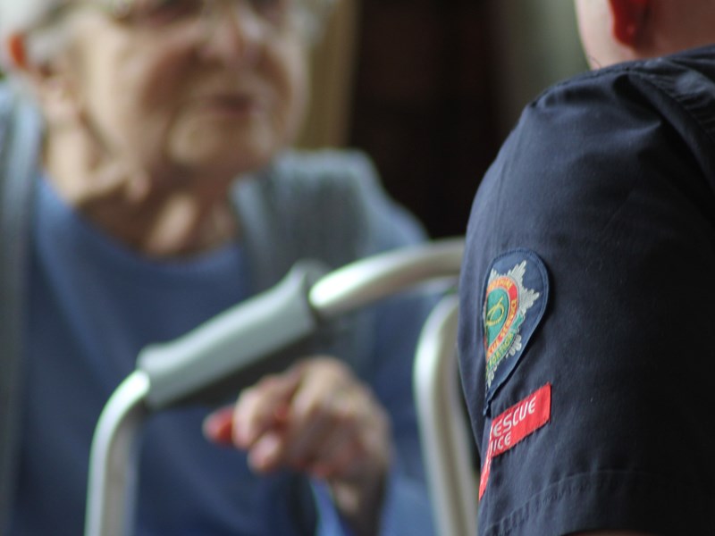 Firefighter talking to elderly person