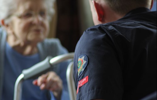 A firefighter talking with an elderly woman (stock)