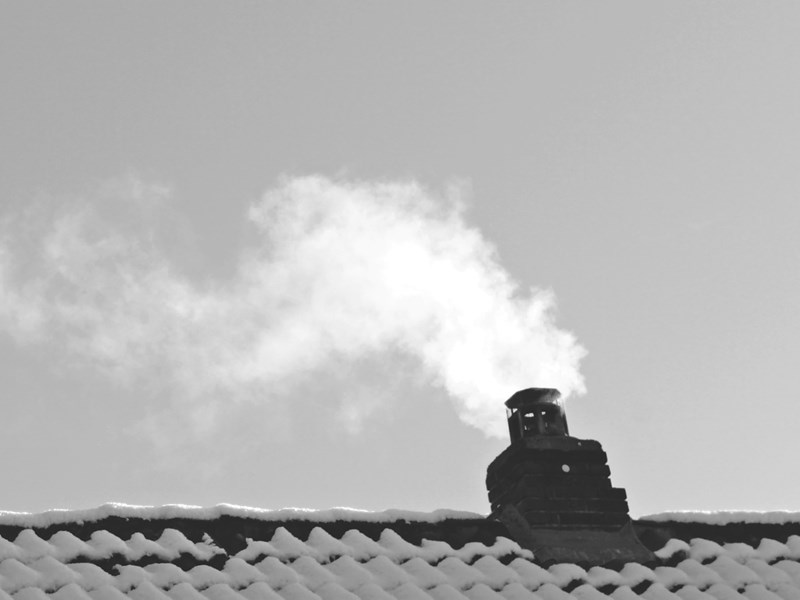 Rooftop chimney billowing smoke