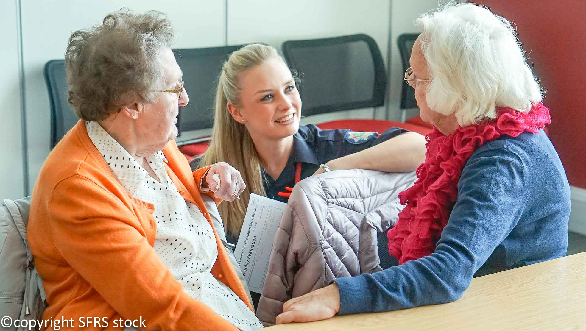 Fire fighter giving safety information to the elderly