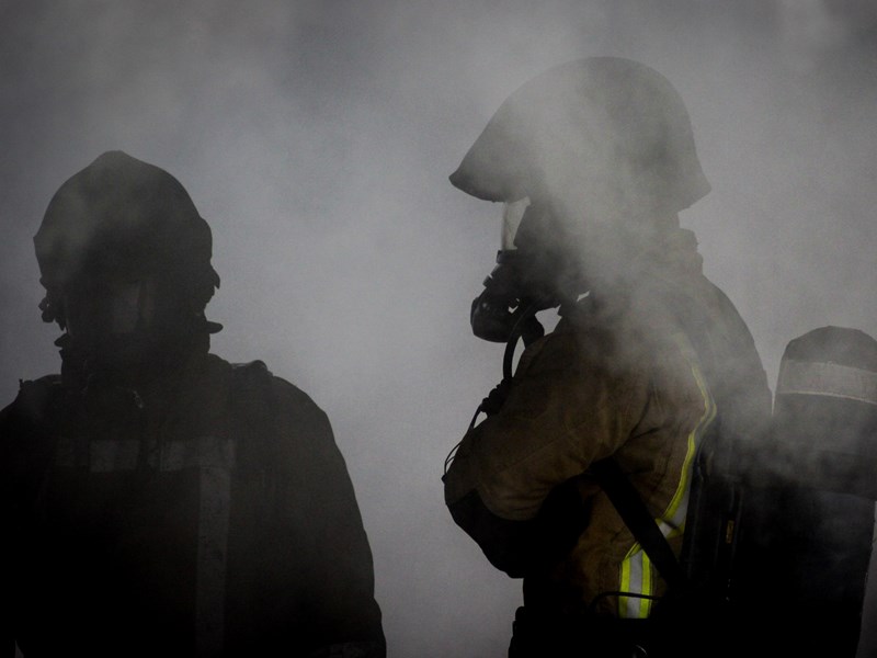 Two firefighter silhouettes in smoke