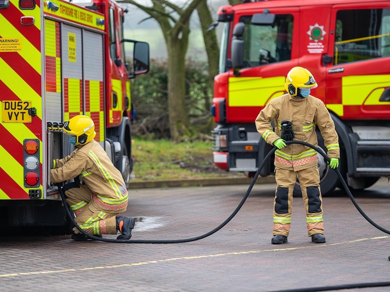 Two firefighters using hose