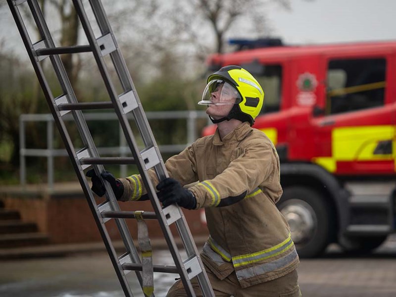 Firefighter climbing ladder