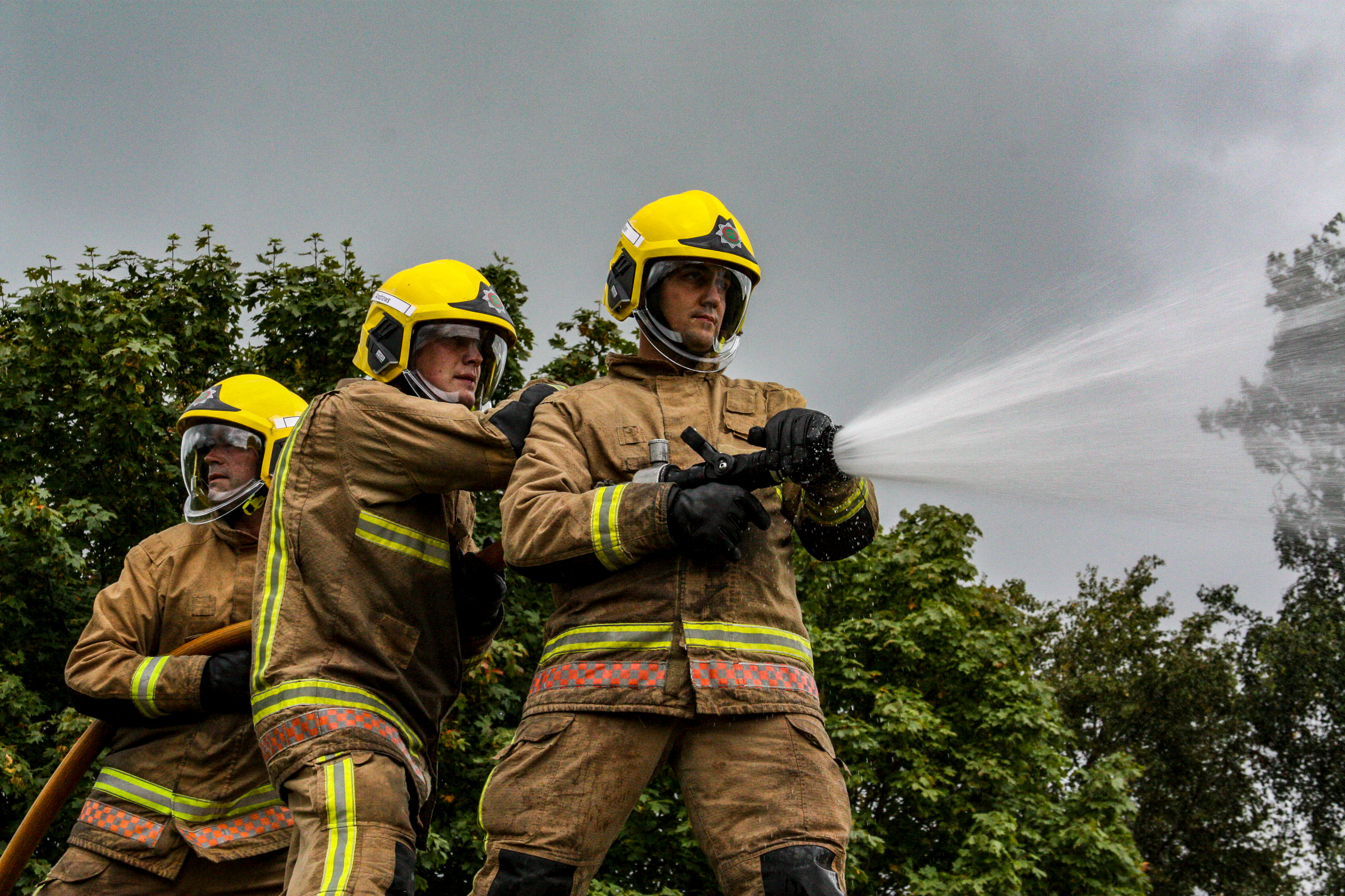 Fire fighters using a hose to spray water