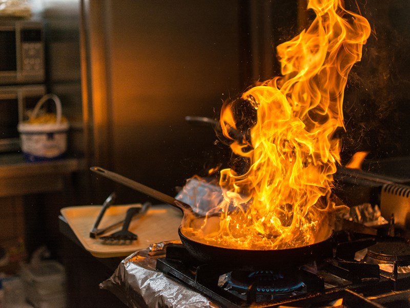 Frying pan on fire in kitchen